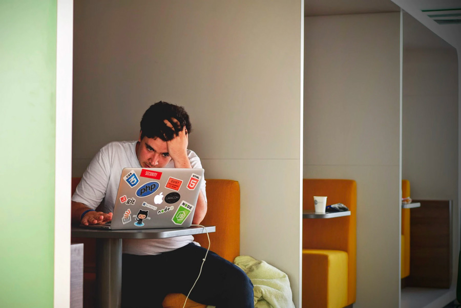 A stressed man looking at the computer